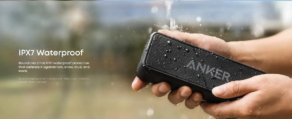 Text reads: 'IP67 Waterproof'. Close-up image of hands holding a black electronic device or speaker against a blurred outdoor background.